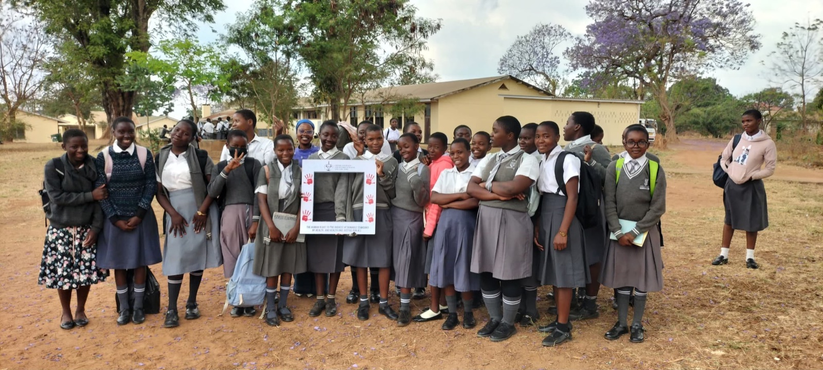 Secondary school learners posing with the CPR frame on campus