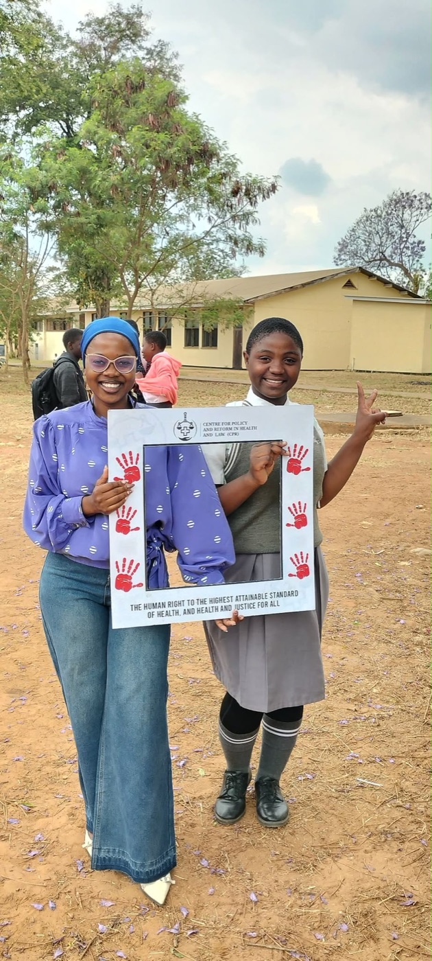 A CPR volunteer and a learner holding the health-rights frame