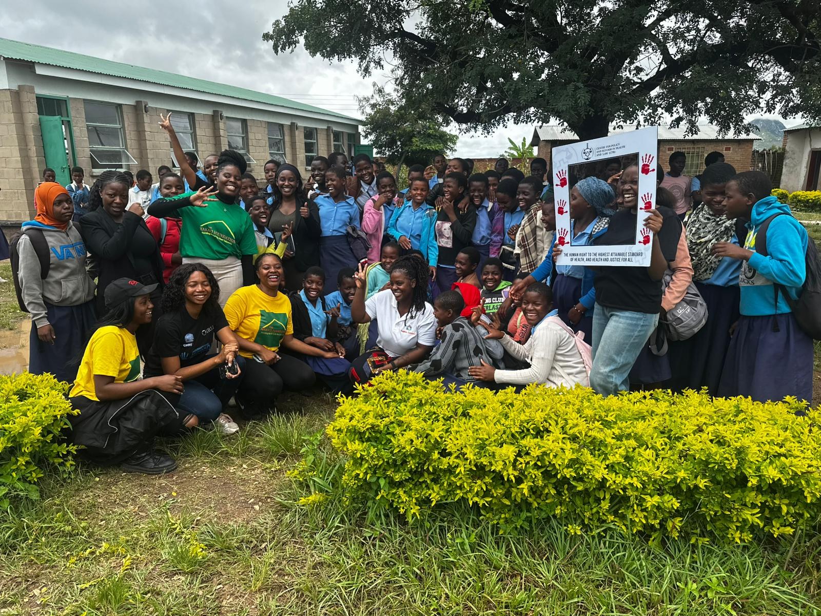 CPR with students after a school session, holding the Centre’s health-rights frame